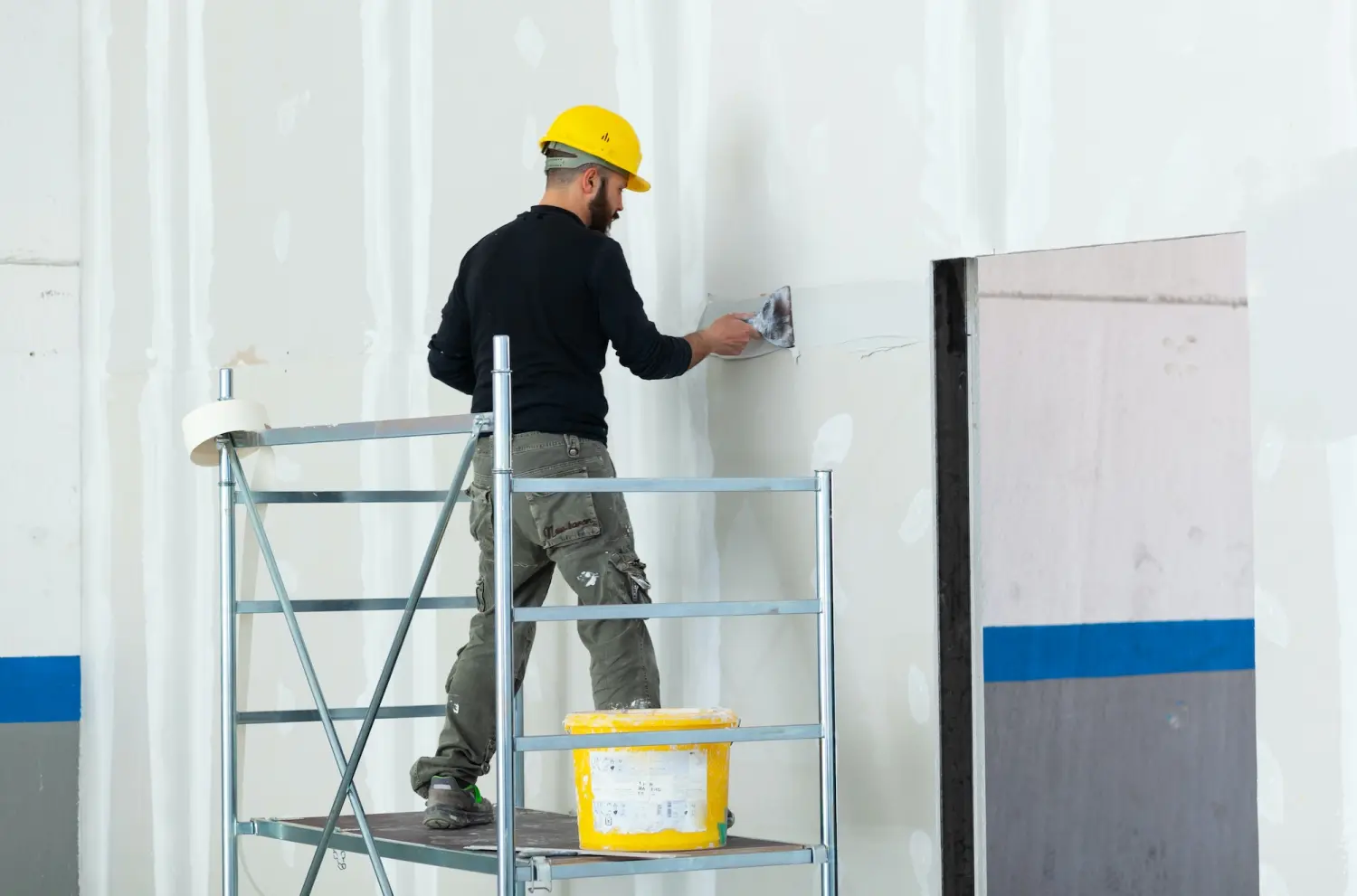 Ewig Bau GmbH - Arbeiter beim Verputzen der Wand